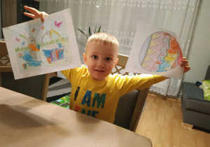 Chłopiec pokazuje swoje rysunki
